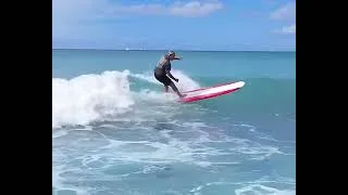 Thumbnail: surfers riding the waves at a public surf break. 