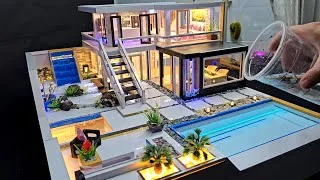 Thumbnail: A waterfall next to the cute miniature house