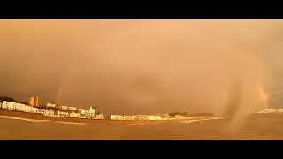 Thumbnail: A very moody and picturesque sky over Hastings. SUP Surfing with a full rainbow.